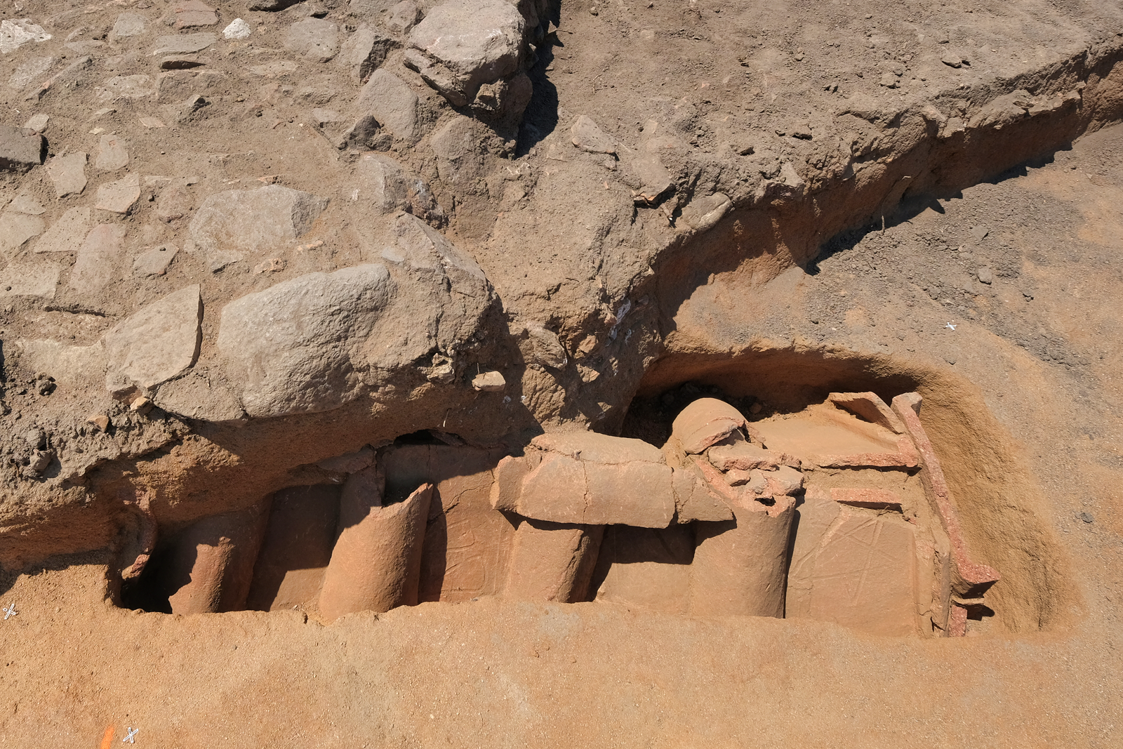 Tombe en bâtière décorée de symboles en traces digitées situées sous l'empierrement